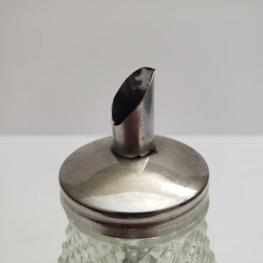 Glass sugar dispenser with a metal lid and spout. 206